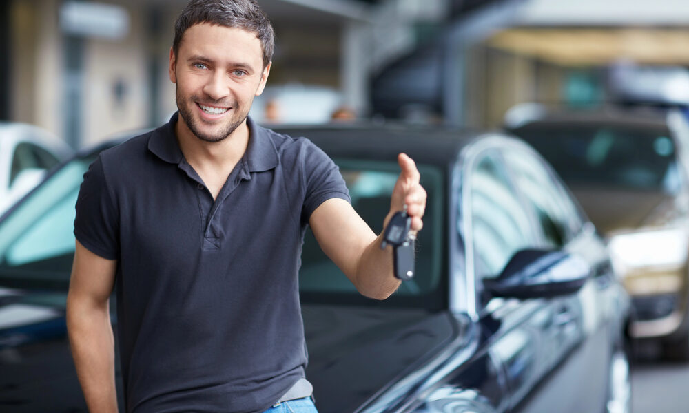 Jongeman met sleutels bij auto